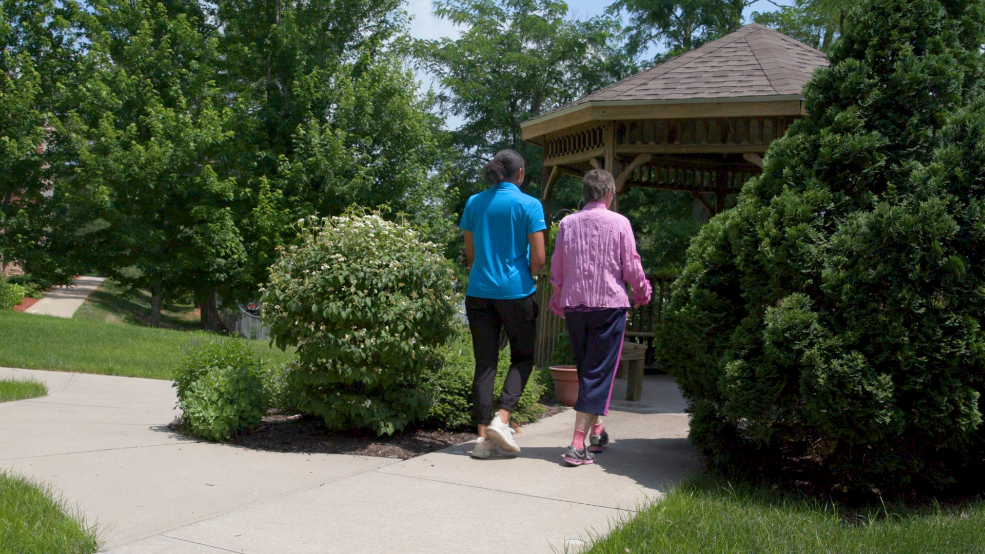 two women walking in garden